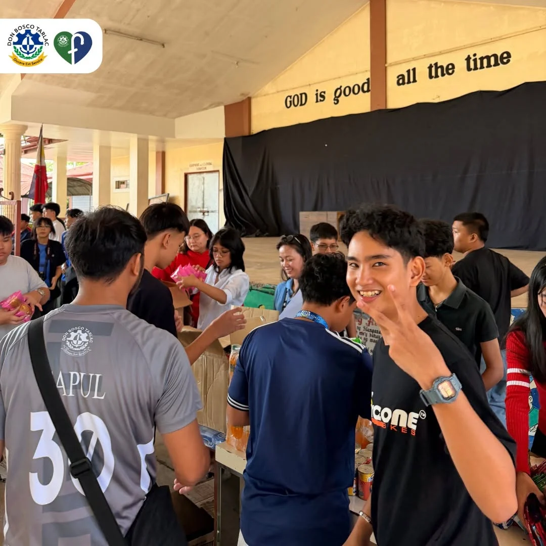 A smiling participant makes a peace sign during a community gathering at AMOR Village.